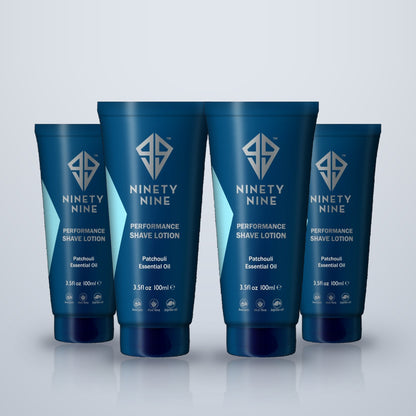 Four blue tubes of Ninety Nine Performance Shave Lotion arranged in a row on a light gray reflective surface.